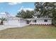 Newly renovated home with gray and white exterior, landscaped yard, and a two-car garage at 11592 110Th Ter, Seminole, FL 33778