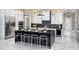Modern kitchen with a large black island, white cabinets, and stainless steel appliances at 14638 Swiss Bridge Dr, Lithia, FL 33547