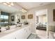 Bright bathroom with double vanity, and view into bedroom at 14814 Paddock Pond Ave, Lithia, FL 33547