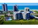 Aerial view of a condo building near the beach, with a pool and tennis courts at 1501 Gulf Blvd # 104, Clearwater Beach, FL 33767
