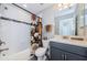 Bathroom with floral shower curtain and gray vanity at 1621 Eagle Creek Dr, Clearwater, FL 33764