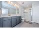 Bathroom with double vanity, large shower, and gray cabinets at 1621 Eagle Creek Dr, Clearwater, FL 33764