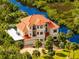 Luxury waterfront home with red tile roof, large balcony, and lush landscaping at 8731 Betty St, Port Richey, FL 34668