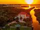 Stunning waterfront property at sunset with boat and dock at 8731 Betty St, Port Richey, FL 34668