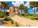 Grand home with a large driveway, palm trees, and beautiful landscaping at 8731 Betty St, Port Richey, FL 34668