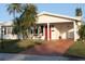 White single-story home with red door, palm trees, and a terracotta driveway at 9705 45Th N Way, Pinellas Park, FL 33782