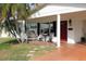 Front porch with red door, wooden swing, and seating area at 9705 45Th N Way, Pinellas Park, FL 33782