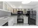 White kitchen with stainless steel appliances and breakfast bar at 105 Island Way # 146, Clearwater, FL 33767