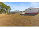 Large backyard with screened pool, detached workshop, and spacious grassy area at 13101 Delbarton St, Spring Hill, FL 34609