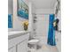 Bathroom with white vanity, blue shower curtain, and tiled floor at 17019 Avon Dive Ln, Wimauma, FL 33598