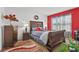 Bright bedroom with a large bed and red accent wall at 17019 Avon Dive Ln, Wimauma, FL 33598