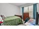 Bright bedroom with a green comforter and wood dresser at 17019 Avon Dive Ln, Wimauma, FL 33598