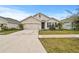 Tan two-story house with a two-car garage and landscaped lawn at 17019 Avon Dive Ln, Wimauma, FL 33598