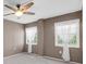 Bright bedroom featuring two windows with sheer curtains and a ceiling fan at 19029 Us Highway 19 N # 26-304, Clearwater, FL 33764