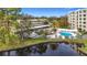 Community pool and surrounding area with lush landscaping and water view at 225 Country Club Dr # 1611, Largo, FL 33771