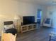 Living area with a TV, comfy chairs, and wood floors at 2465 Northside Dr # 1203, Clearwater, FL 33761