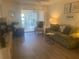 Spacious living room with green couch and wood-look floors at 2465 Northside Dr # 1203, Clearwater, FL 33761