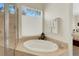 Relaxing bathroom with a corner bathtub, large window, and neutral color scheme at 2850 Deer Run, Tarpon Springs, FL 34688