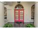 Pink double front doors with glass panels and arched entryway at 2850 Deer Run, Tarpon Springs, FL 34688
