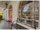 Front porch with pink door, arched windows, and a bench at 2850 Deer Run, Tarpon Springs, FL 34688
