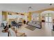 Bright living room features a comfy sofa and armchairs, adjacent to a kitchen with white cabinets at 2850 Deer Run, Tarpon Springs, FL 34688