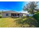 Large backyard with grassy area, covered patio, and fire pit at 3407 Walden Reserve Dr, Plant City, FL 33566