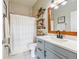 Updated bathroom with gray vanity, white shower curtain, and patterned floor at 3407 Walden Reserve Dr, Plant City, FL 33566
