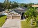 Tan house with three-car garage and palm trees at 3407 Walden Reserve Dr, Plant City, FL 33566