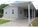 Gray mobile home with covered carport and screened porch at 3722 Spinnaker Dr, Tampa, FL 33611