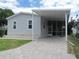 Gray mobile home with covered carport and paved driveway at 3722 Spinnaker Dr, Tampa, FL 33611