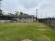 Large grass backyard featuring a black fence and a view of the home at 442 Country Club Dr, Oldsmar, FL 34677
