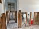 Hallway view of bathroom under repair; exposed studs, open doorway, and new fixtures at 442 Country Club Dr, Oldsmar, FL 34677
