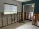 Living room with exposed wall studs, window, and open space, awaiting renovation at 442 Country Club Dr, Oldsmar, FL 34677