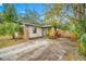 House with a yellow door, brick facade, and a paved driveway at 505 Jefferson S Ave, Oldsmar, FL 34677