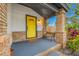 Inviting porch with a yellow door and a wooden bench at 505 Jefferson S Ave, Oldsmar, FL 34677