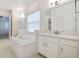 Bathroom with soaking tub, double vanity, and white tile at 5322 Windy Grove Dr, Wimauma, FL 33598