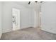 Well-lit bedroom with carpet flooring and multiple doorways at 5322 Windy Grove Dr, Wimauma, FL 33598