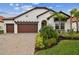 Two-story home with attractive landscaping and a three-car garage at 5322 Windy Grove Dr, Wimauma, FL 33598