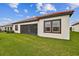 Rear view of house showcasing screened patio and well-maintained lawn at 5322 Windy Grove Dr, Wimauma, FL 33598