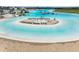 Sandy beach and lounge chairs surrounding lagoon pool at 5322 Windy Grove Dr, Wimauma, FL 33598