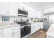 Modern kitchen with white cabinets, stainless steel appliances, and an island at 5736 Biscayne Ct # 3, New Port Richey, FL 34652