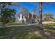 White A-frame home with a stone fireplace and mature trees at 705 Whiteway Dr, Brooksville, FL 34601
