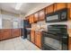 Kitchen boasts wood cabinets, black appliances, and a microwave at 706 Haven Pl, Tarpon Springs, FL 34689