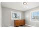 Bright bedroom with wood dresser, two windows, and light grey walls at 1198 40Th Ne Ave, St Petersburg, FL 33703