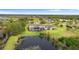 Aerial view featuring the backyard, lake, and screened pool of an expansive estate home on manicured acreage at 12405 Stonelake Ranch Blvd, Thonotosassa, FL 33592