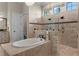 Luxurious bathroom features a soaking tub, glass shower enclosure, and neutral tiles for a spa-like experience at 12405 Stonelake Ranch Blvd, Thonotosassa, FL 33592