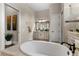 Elegant bathroom features a soaking tub, a vanity with a large mirror, and neutral tones at 12405 Stonelake Ranch Blvd, Thonotosassa, FL 33592