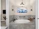 Serene bathroom features a soaking tub, artistic wall decor, and tile flooring for a peaceful retreat at 12405 Stonelake Ranch Blvd, Thonotosassa, FL 33592