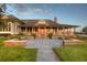 Beautiful home featuring a covered porch, well-manicured lawn, and stone patio at 12405 Stonelake Ranch Blvd, Thonotosassa, FL 33592