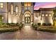 Inviting front entrance featuring a decorative wrought iron door, manicured landscaping, and paver walkway at 12405 Stonelake Ranch Blvd, Thonotosassa, FL 33592